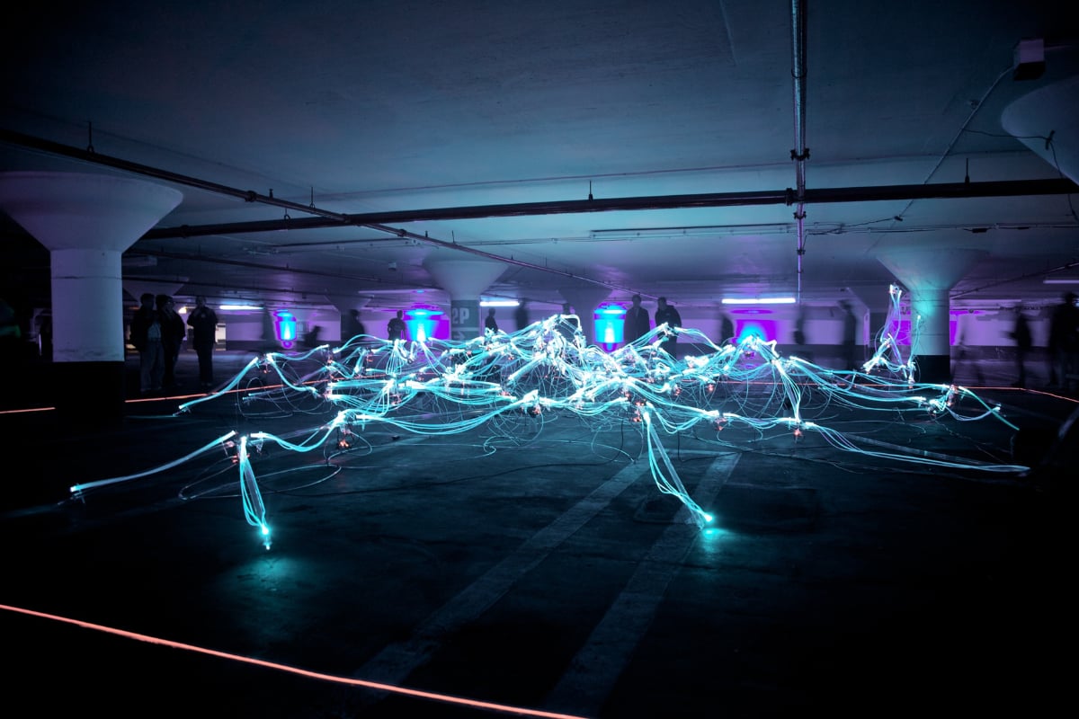 Light art installation with cables and fiber optics in an underground parking, illustrating networks, connectivity and data
