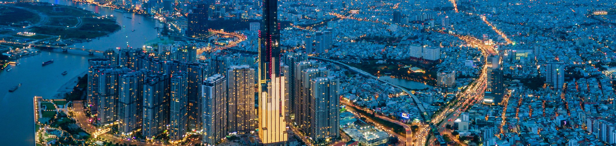Iconic skyscraper overlooking a large Asian city at dusk, illustrating urbanization, economic growth and emerging markets
