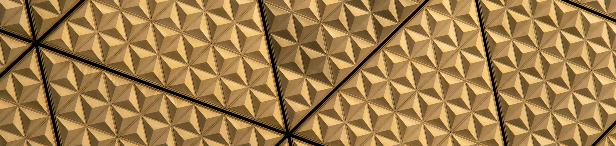 Gold geometric embossed pattern with repeating texture, evoking luxury and structure