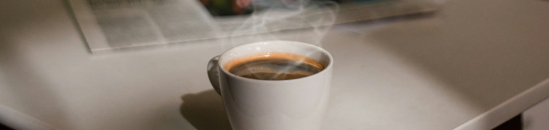 Cup of coffee beside a financial newspaper, symbolizing market analysis, investment insights and economic commentary
