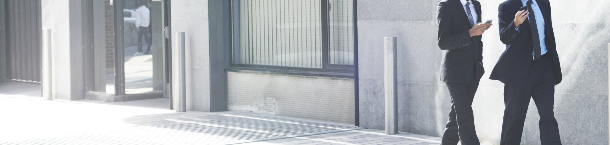 Two business professionals discussing financial markets and investment strategy outside a modern office building