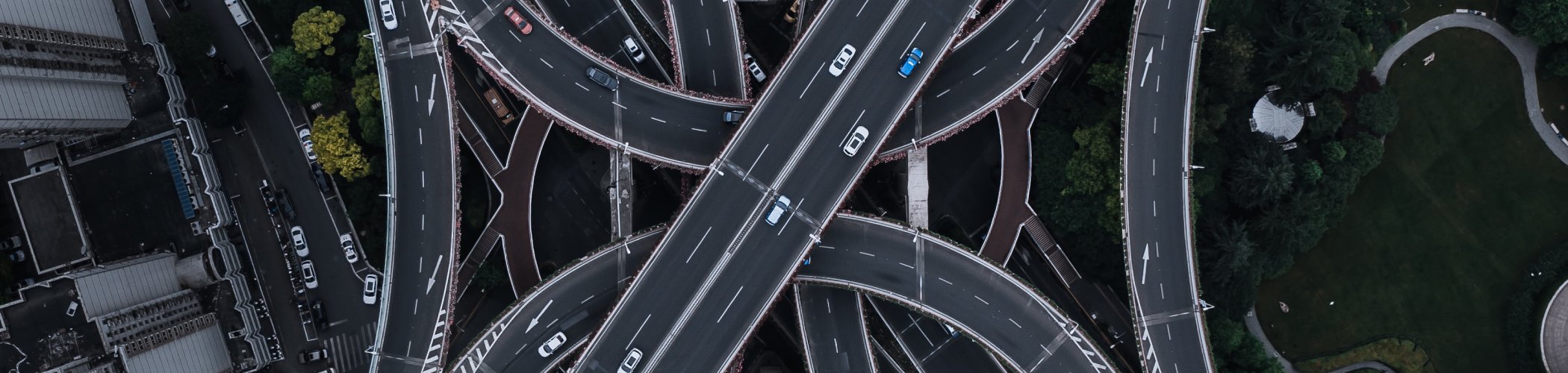 Aerial view of a complex highway interchange with cars in motion, illustrating connectivity, infrastructure and traffic flow
